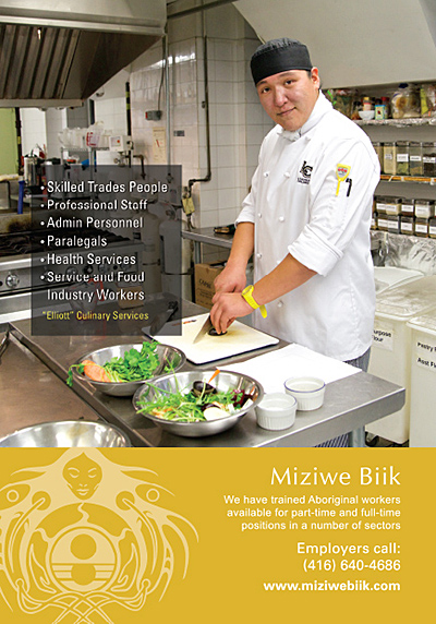 A man chopping up food in a restaurant kitchen.